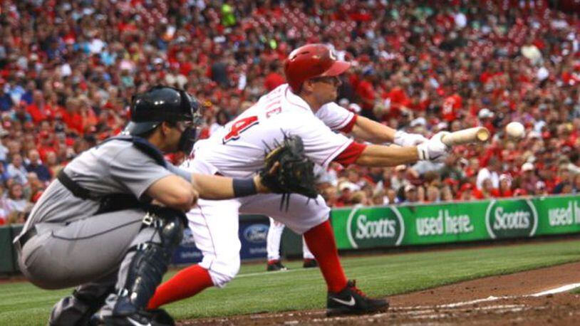 Reds pitcher Mike Leake lays down a sacrifice bunt. The Reds lost 4-2 to the Mariners on Friday, July 5, 2013, at Great American Ball Park in Cincinnati.