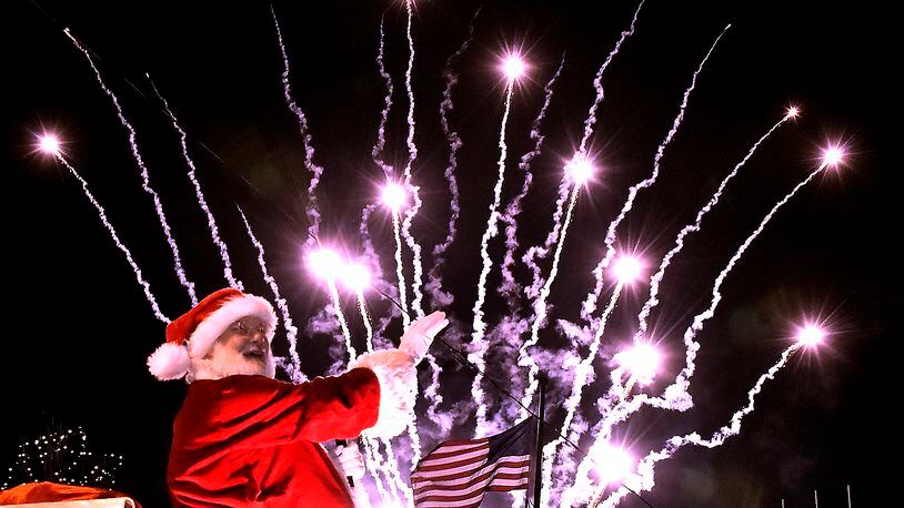 Santa turns and waves to the crowd as fireworks launch behind him on the Springfield City Hall Plaza during the Holiday in the City festival in 2016. Bill Lackey/Staff