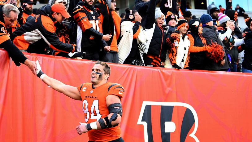 FILE - Cincinnati Bengals defensive end Sam Hubbard (94) high-fives fans after the team's NFL football game against the Pittsburgh Steelers on Nov. 28, 2021, in Cincinnati. Hubbard grew up in Cincinnati and followed the “Bungles” as they stumbled and bumbled throughout much of his youth. His first three years as a Bengals were pretty much the same. “It’s just really cool how many people have thanked me for the relief they’ve felt, the time that they had watching the games, the great memories they’ve had from these wins this year,” Hubbard said. (AP Photo/Emilee Chinn, File)