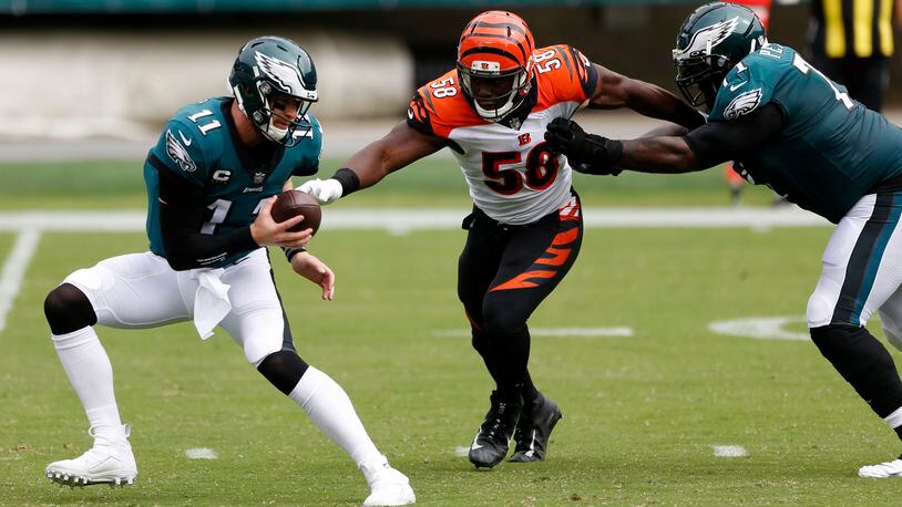 Philadelphia Eagles' Carson Wentz (11) tries to escape from Cincinnati Bengals' Carl Lawson (58) as Jason Peters (71) defends during the first half of an NFL football game, Sunday, Sept. 27, 2020, in Philadelphia. (AP Photo/Laurence Kesterson)
