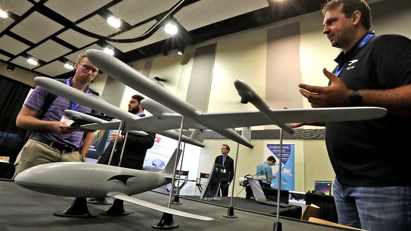 Jordan Thompson, right, from Talyn Air, talks with Alex Zorniger about the design of their craft Monday, August 22, 2022 during the National Advanced Air Mobility Industry Forum at Clark State's Hollenbeck-Bailey Conference Center in Springfield. BILL LACKEY/STAFF