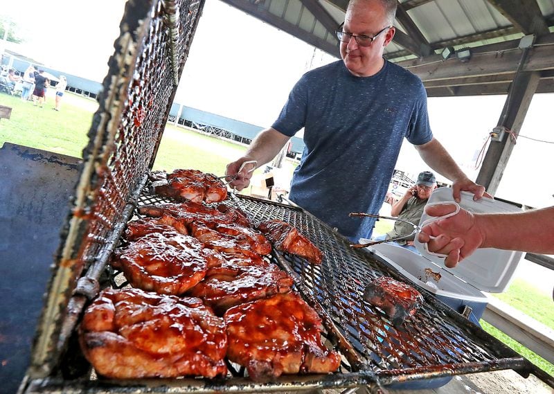 Jim Dempsey helps take the world famous Clark County Fair pork chops off the grill Friday during the opening day of the fair. BILL LACKEY/STAFF