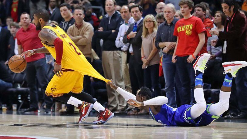 Cavaliers guard Kyrie Irving, who led the team with 43 points, is fouled while driving past Hawks guard Dennis Schroder in the final minutes of Cleveland's 135-130 victory Friday night.
