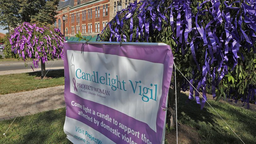 The trees and bushes around the Esplanade in downtown Springfield were decorated with purple ribbons for the Project Woman Candlelight Vigil for domestic violence last year. BILL LACKEY/STAFF