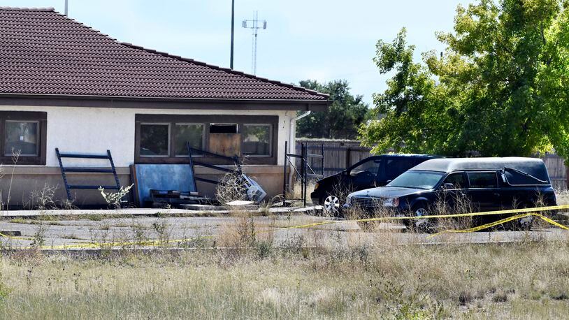 FILE - A hearse and debris can be seen at the rear of the Return to Nature Funeral Home, Oct. 5, 2023, in Penrose, Colo. The couple who owned the Colorado funeral home — where 190 decaying bodies were discovered last year — have been indicted on federal charges for fraudulently obtaining nearly $900,000 in pandemic relief funds from the U.S. government, according to court documents unsealed Monday, April 15, 2024. (Jerilee Bennett/The Gazette via AP, File)