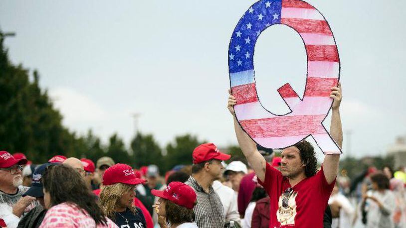 David Reinert holding a Q sign waits in line with others to enter a campaign rally with President Donald Trump and U.S. Senate candidate Rep. Lou Barletta, R-Pa., Thursday, Aug. 2, 2018, in Wilkes-Barre, Pa.