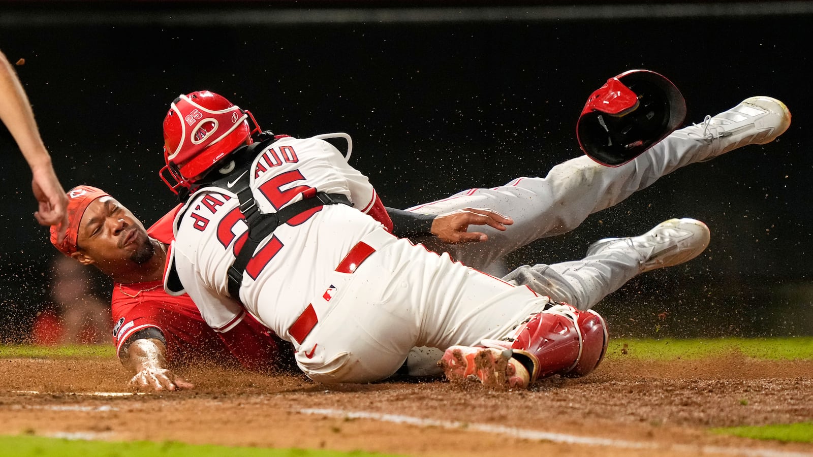 Cincinnati Reds' Will Benson, left, is tagged out by Los Angeles Angels catcher Travis d'Arnaud while trying to score on a double by Gavin Lux during the ninth inning of a baseball game Tuesday, Aug. 19, 2025, in Anaheim, Calif. (AP Photo/Mark J. Terrill)