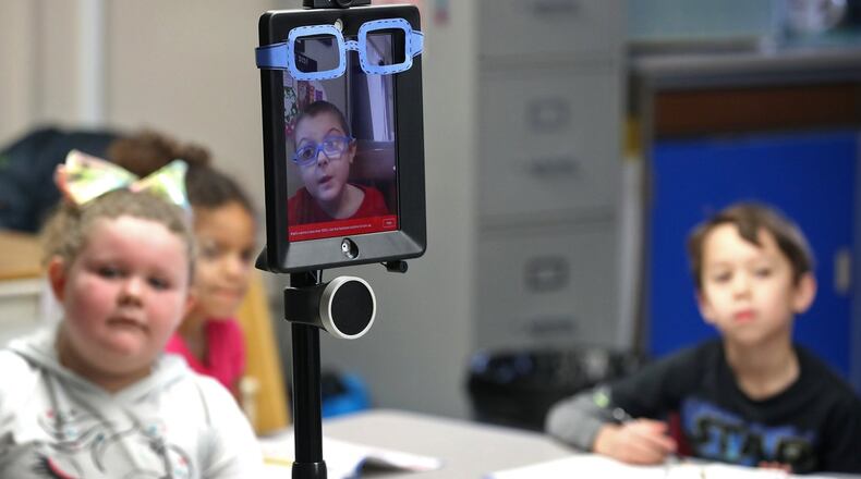 Thanks to a robot designed by the Ohio State University engineering department, Levi Suttles, 6, is still able to attend school at Miami View School in South Charleston despite battling leukemia. The robot allows Levi to move around and interact with his class from a computer at home. BILL LACKEY/STAFF