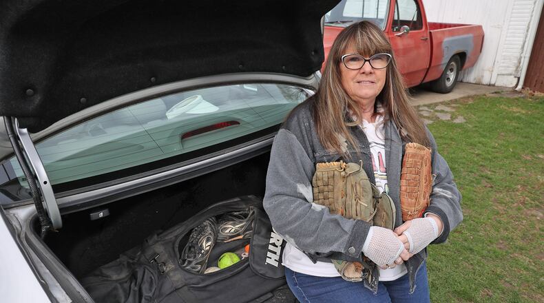 Rosa Tuttle, holds she and and her late husband's softball gloves. The two met on the softball field and were married 30 years. BILL LACKEY/STAFF