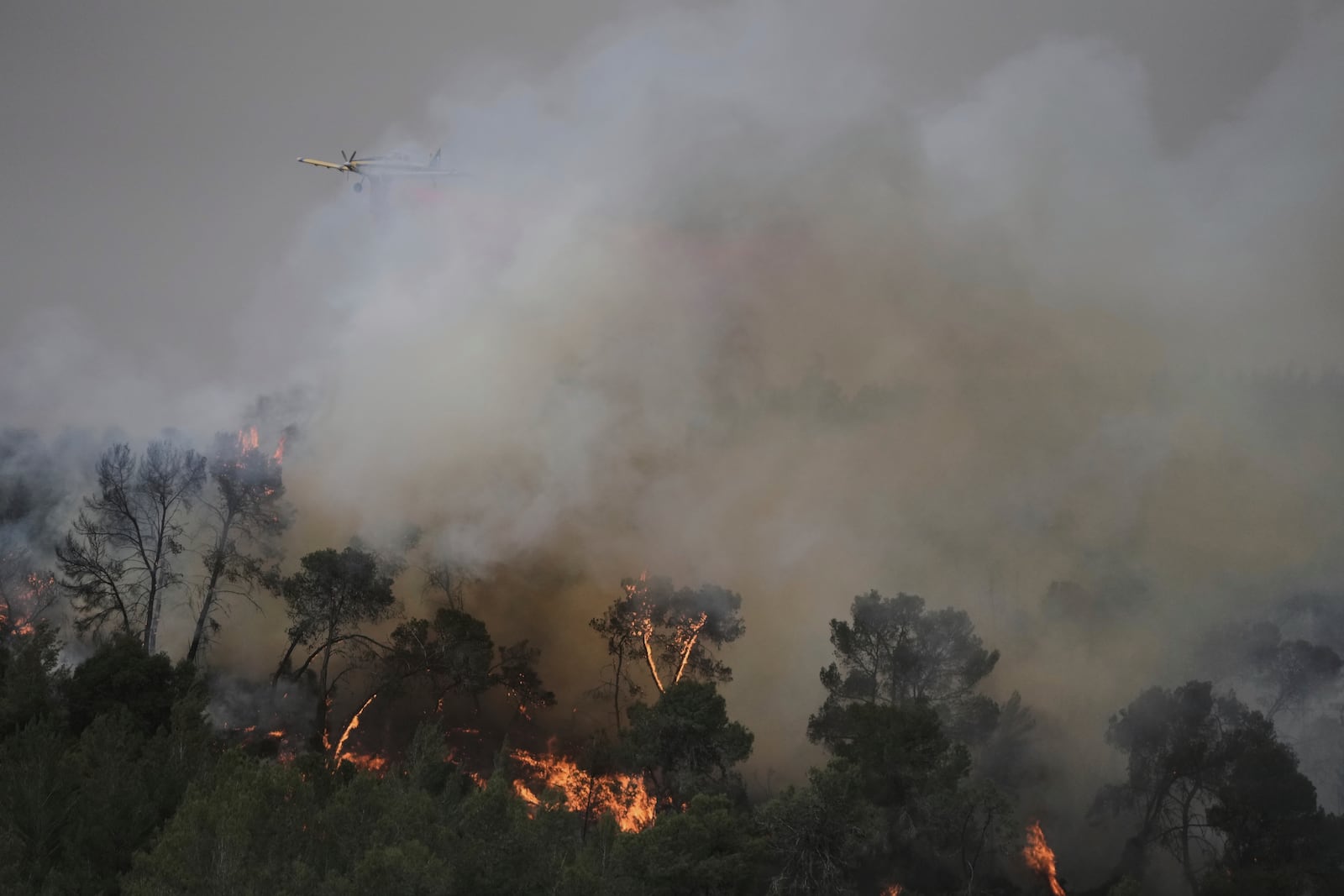 A plane uses a fire retardant to extinguish a fire burning in a forest near Jerusalem, Wednesday, April 30, 2025. (AP Photo/Mahmoud Illean)