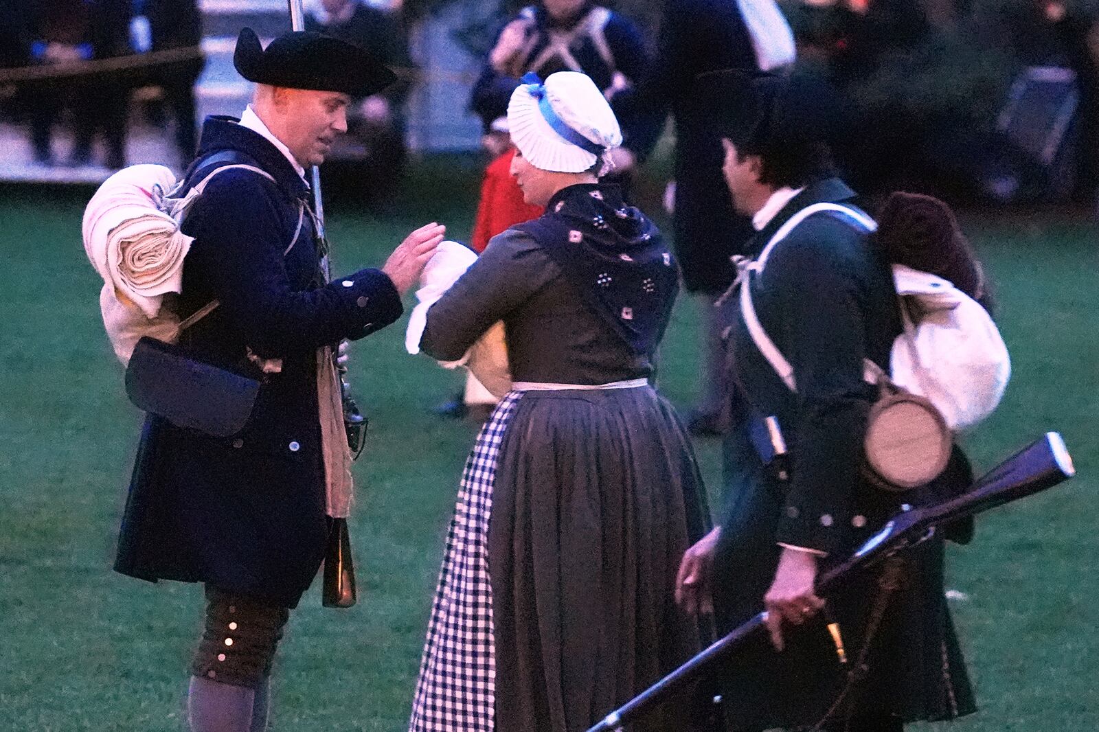 A New England colonial militia man, also known as a Minuteman, caresses the head of a baby prior to facing the British Regulars during a reenactment celebration of the 250th anniversary of the Battle of Lexington and start of the American Revolution, Saturday, April 19, 2025, in Lexington, Mass. (AP Photo/Charles Krupa)