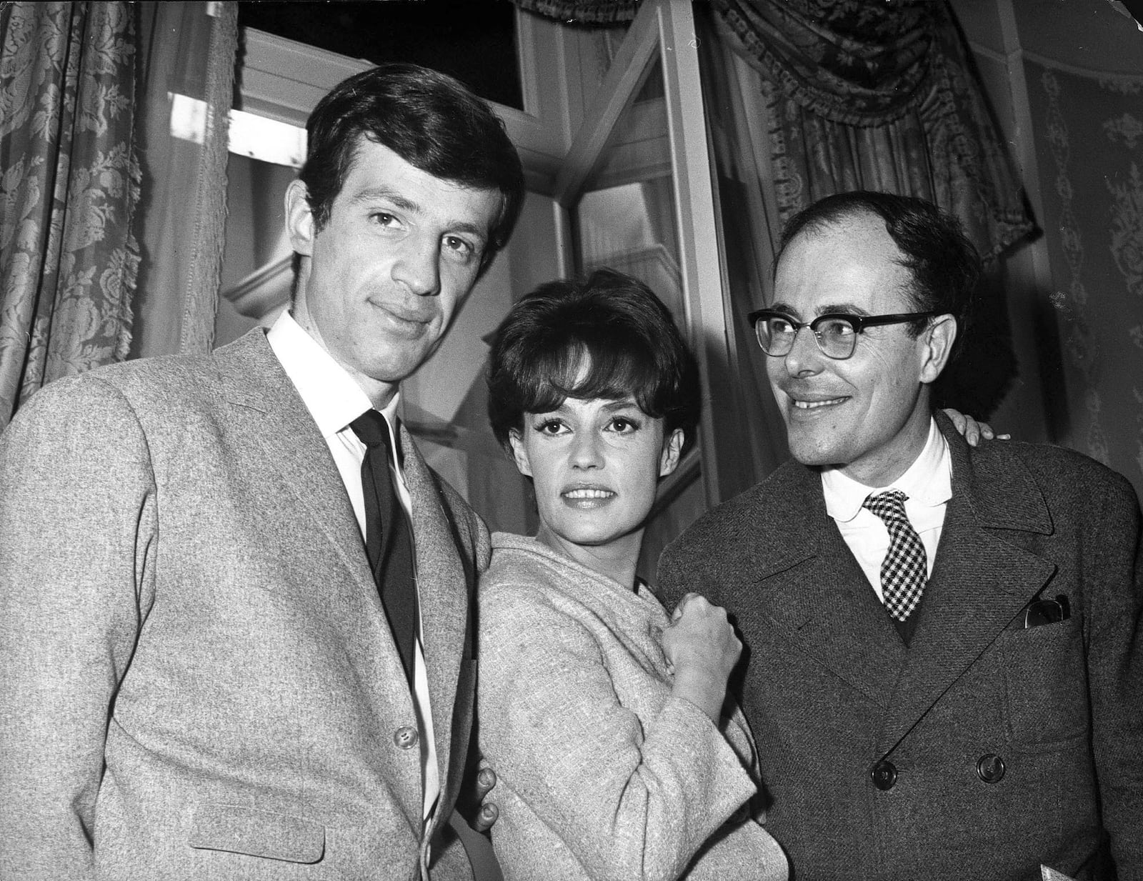 File - left to right; actors Jean Paul Belmondo, Jeanne Moreau and director Marcel Ophuls pose on the set of Banana Skin - Peau de Banane, Feb. 26, 1963, at Billancourt studios near Paris. (AP Photo/Pierre Godot, File)