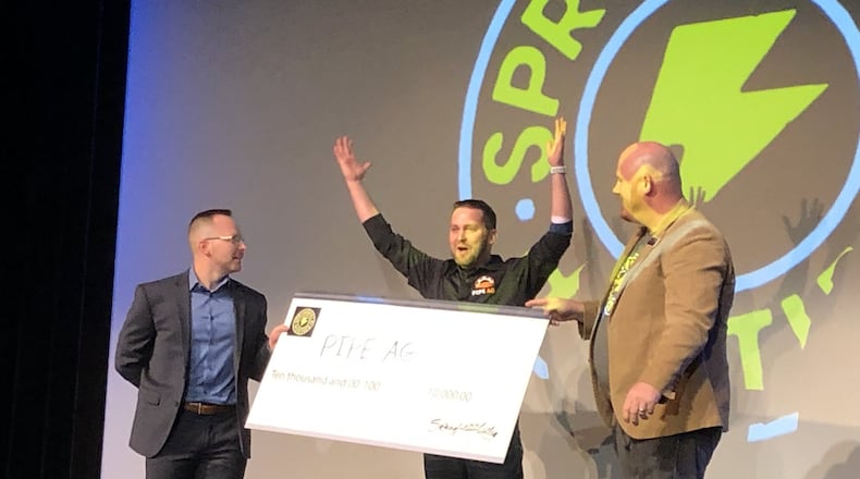 Roark Thompson of PIPE Ag celebrates winning the first Springfield Hustles grand prize with a check offered by Blake Shaffer, left, and Rob Alexander at the John Legend Theater on Wednesday. Photo by Brett Turner