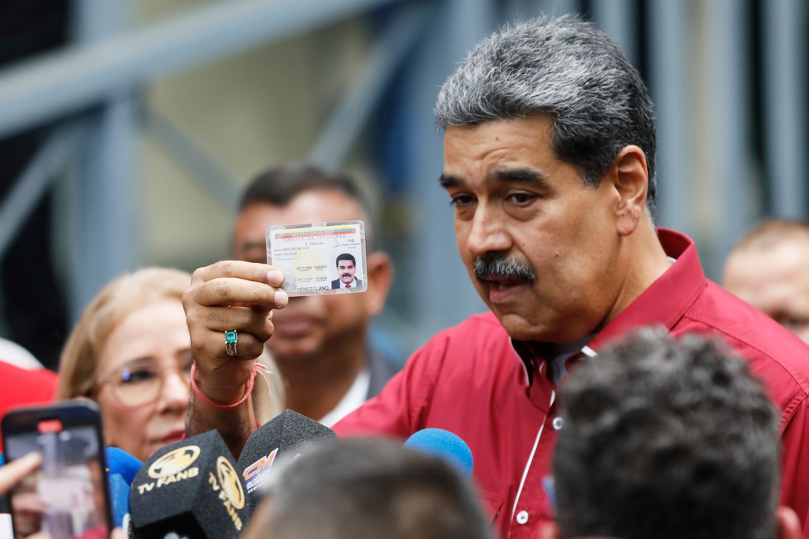 Venezuela's President Nicolas Madurai shows his ID to journalists after voting in legislative and local elections in Caracas, Venezuela, Sunday, May 25, 2025. (AP Photo/Cristian Hernandez)