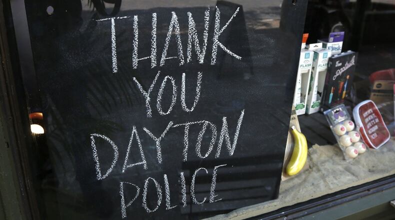 Signs supporting the Dayton Police Department can be found throughout the Oregon District, including this chalkboard sign at Heart Mercantile. STAFF FILE