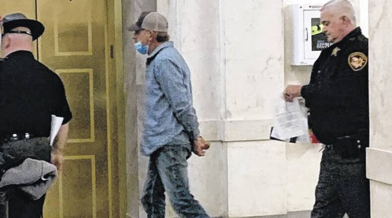 Brian Liming of Greene County is escorted by Clinton County Sheriff's deputies following his arrest Thursday on a federal warrant. JOHN HAMILTON / WiILMINGTON NEWS JOURNAL
