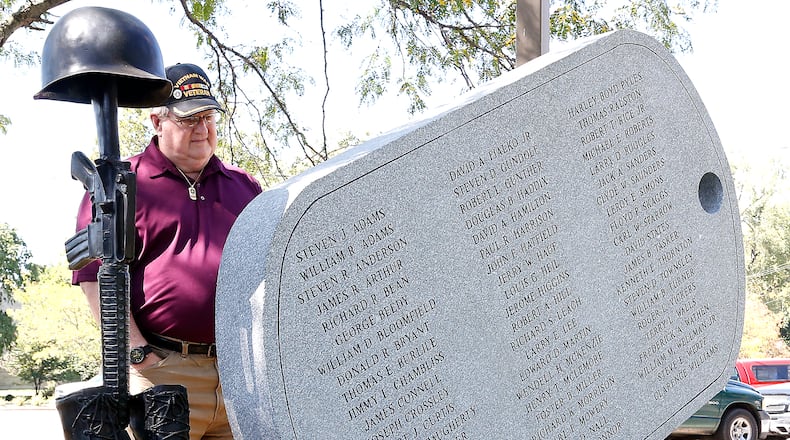 Randy Ark looks over the inscription on the back of the Vietnam Veterans Memorial in Veterans Park. The dog tag shaped stone features the names of the men killed in Vietnam. Bill Lackey/Staff