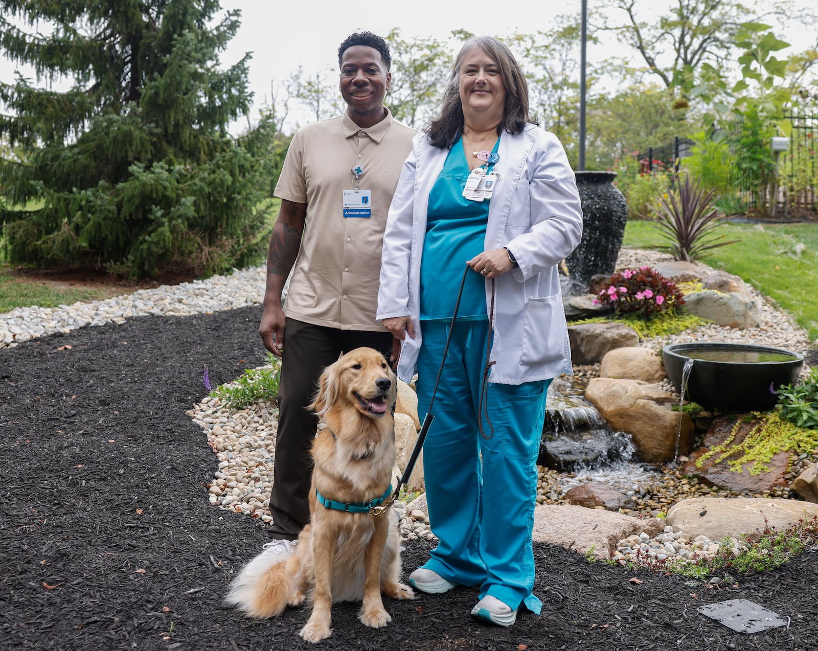 Tunnel CEO Brad Soles, left, and Nancy Schmelzer, PMHNP-BC, pose for a photo next to Beau, a new therapy dog, on Wednesday, Oct. 15, 2025, at Mercy Health Springfield. JOSEPH COOKE/STAFF
