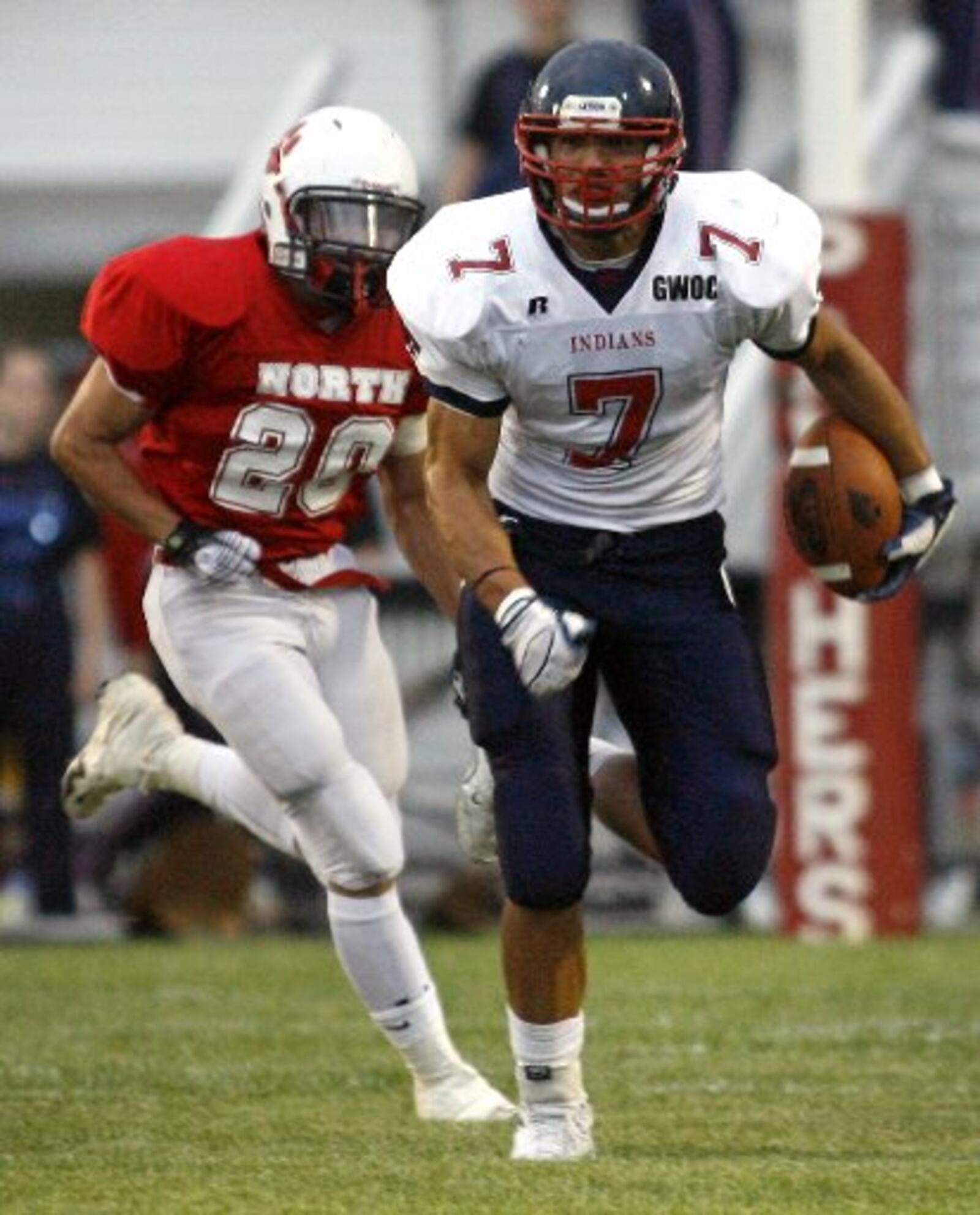 David Rolf (7) of Piqua High School is pursued by John Robinson (20) of Springfield North High School during Friday's game at North. Staff Photo by Barbara J. Perenic