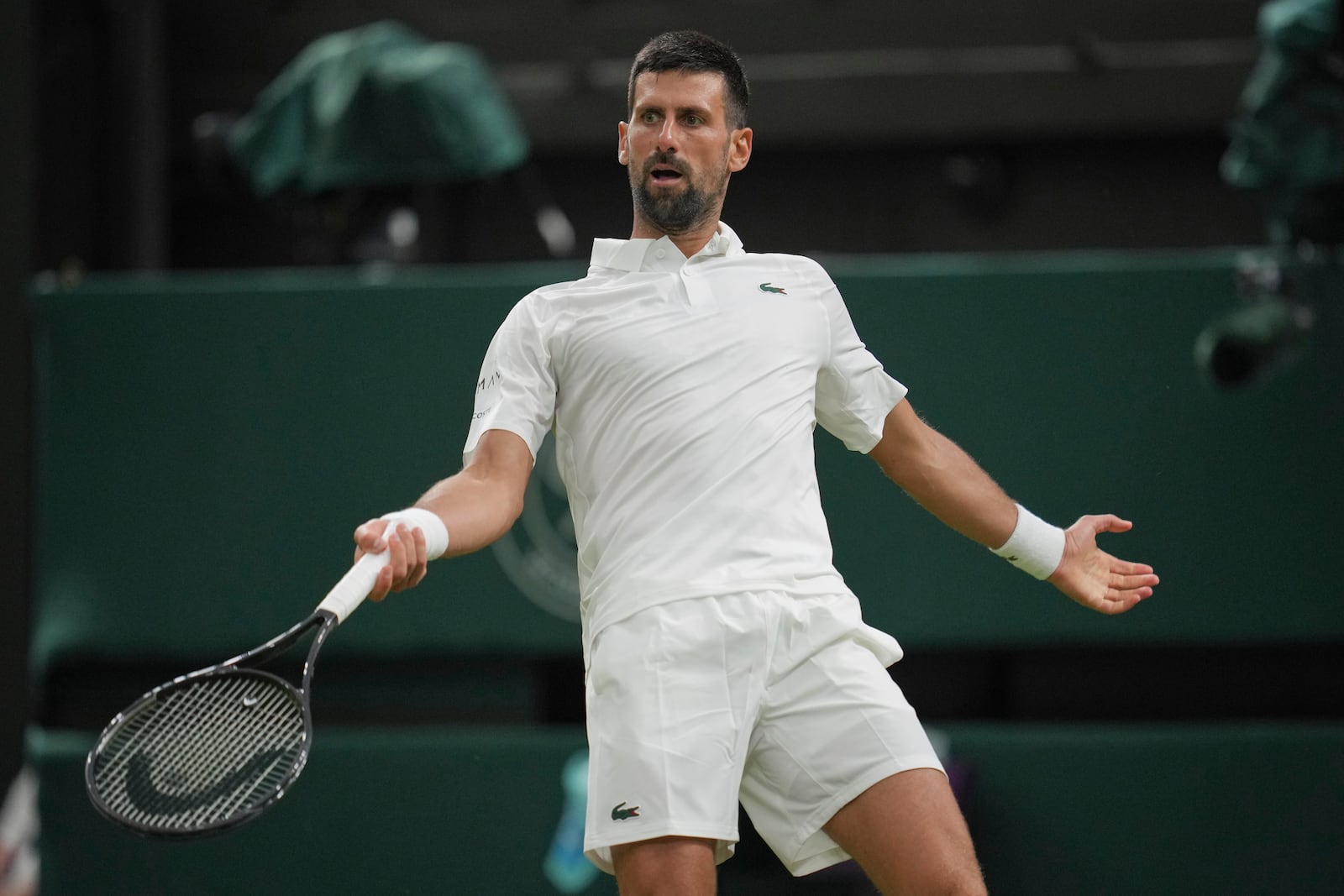 Novak Djokovic of Serbia reacts as he plays Alexandre Muller of France during their first round men's singles match at the Wimbledon Tennis Championships in London, Tuesday, July 1, 2025. (AP Photo/Kin Cheung)