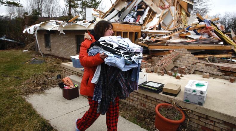 Rebekah Stewart sorts through what’s left of her families house for clothes and personal belongings Wednesday afternoon. Wednesday’s storm destroyed Rebekah’s home and severely damaged several others on Mitchell Road. BILL LACKEY/STAFF