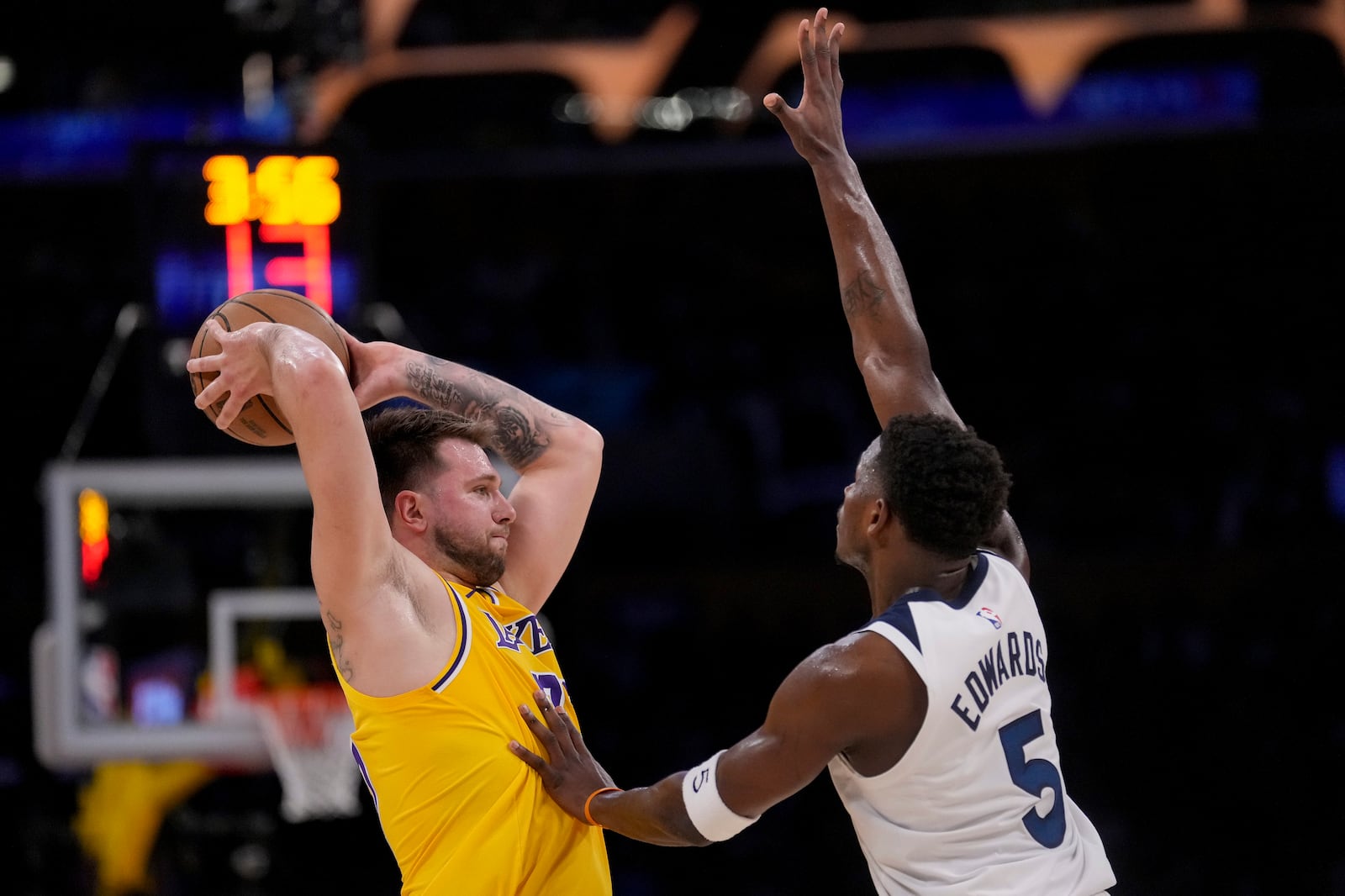 Los Angeles Lakers guard Luka Doncic (77) looks to pass around Minnesota Timberwolves guard Anthony Edwards (5) during the first half of Game 2 of an NBA basketball first-round playoff series in Los Angeles, Tuesday, April 22, 2025. (AP Photo/Eric Thayer)