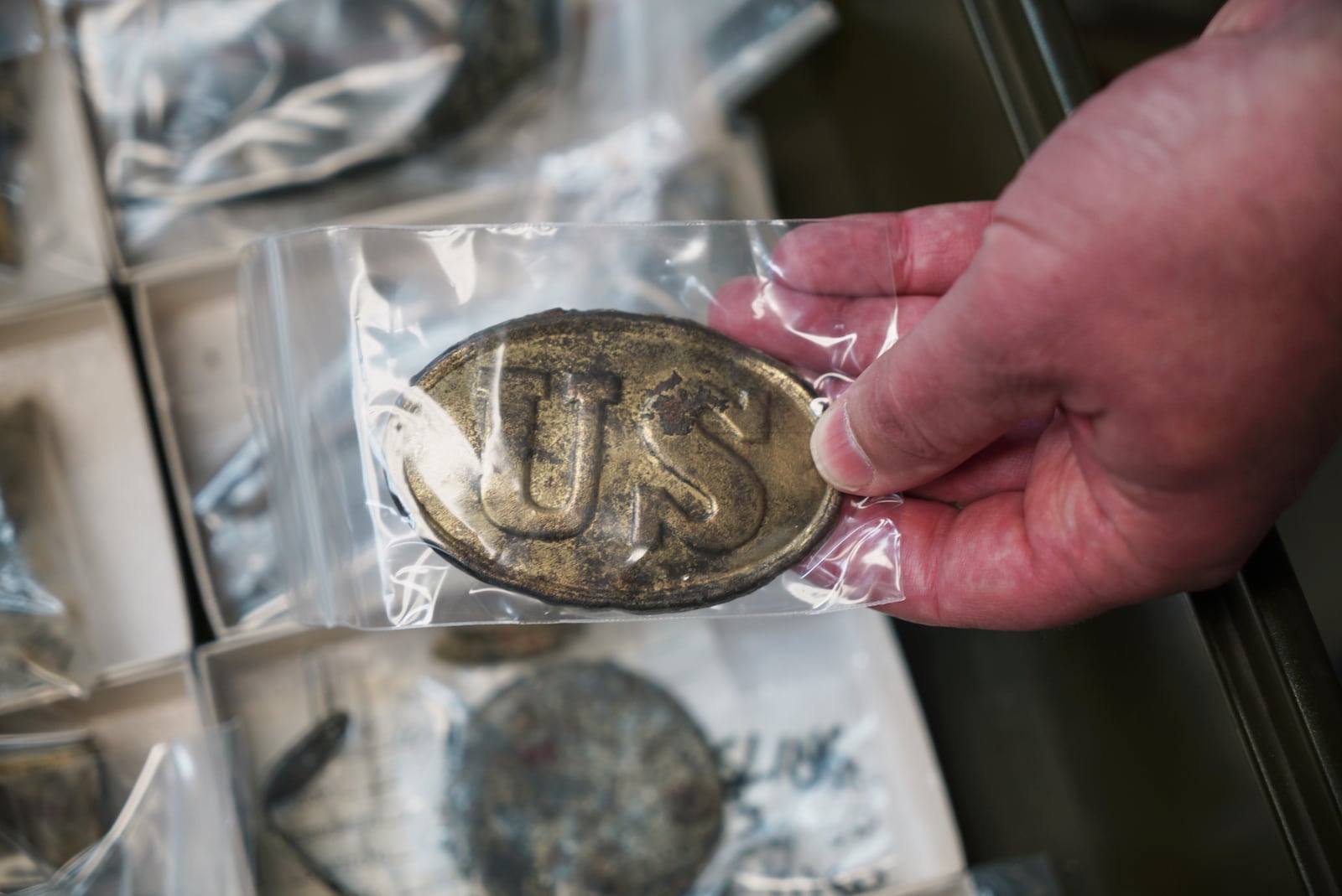 Jack Gary holds a Union soldier's belt buckle from the collections in Williamsburg, Va., on May 29, 2025. (AP Photo/Allen G. Breed)