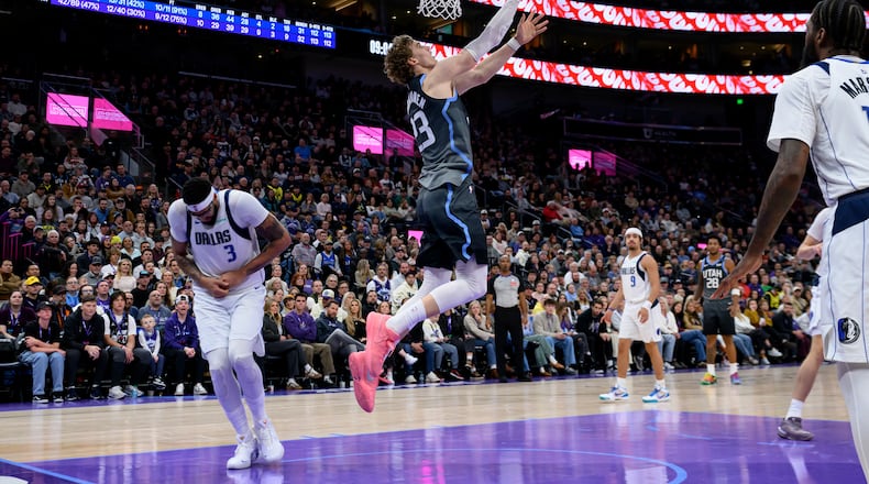 Utah Jazz forward Lauri Markkanen, center, lays the ball to the basket as Dallas Mavericks forward Anthony Davis, left, is injured on the play during the second half of an NBA basketball game against the Dallas Mavericks, Thursday, Jan. 8, 2026, in Salt Lake City. (AP Photo/Tyler Tate)