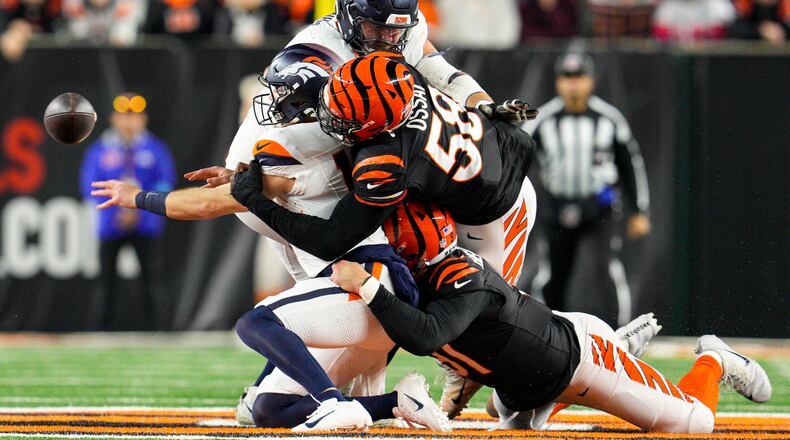 Denver Broncos quarterback Bo Nix (10) is sacked by Cincinnati Bengals defensive end Joseph Ossai (58) and defensive end Trey Hendrickson (91) during the first half of an NFL football game in Cincinnati, Saturday, Dec. 28, 2024. (AP Photo/Jeff Dean)