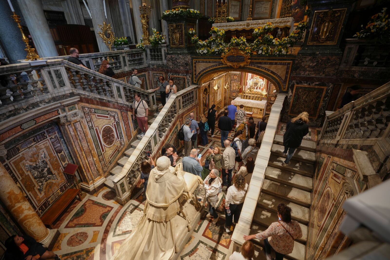 Faithful and nuns gather by the statue of Pope Pius IX, inside in St. Mary Major basilica, where Pope Francis will be buried, in Rome, Tuesday, April 22, 2025. (AP Photo/Alessandra Tarantino)