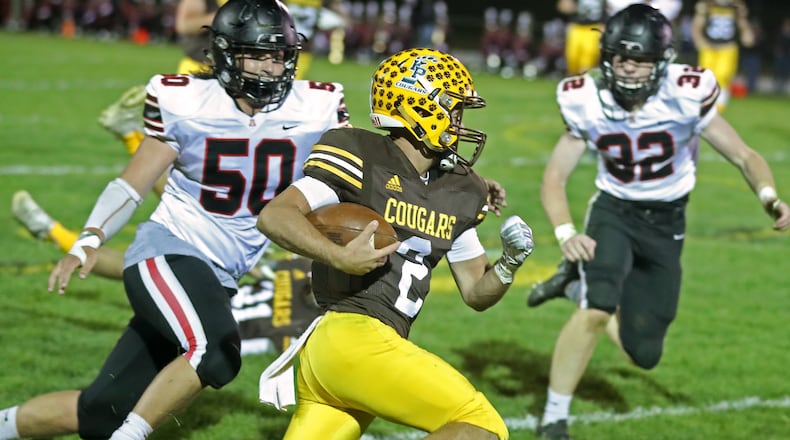 Kenton Ridge’s Dylan Lemen tries to avoid Jonathan Alder’s Conner Morgan, left, and Logan Shafley, during a game earlier this season. BILL LACKEY/STAFF