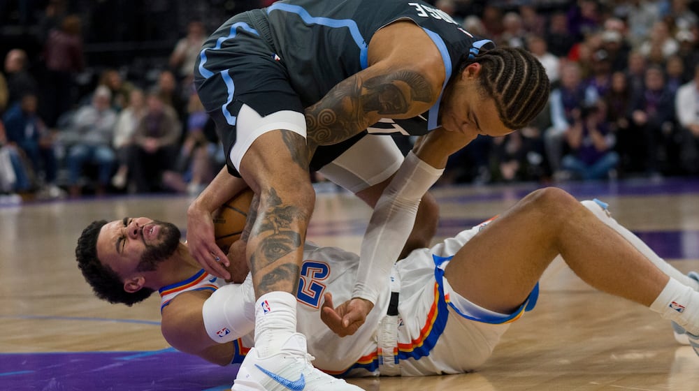 Utah Jazz guard Keyonte George, top, and Oklahoma City Thunder guard Ajay Mitchell (25) fight for the ball during the first half of an NBA basketball game Sunday, Dec. 7, 2025, in Salt Lake City. (AP Photo/Bethany Baker)