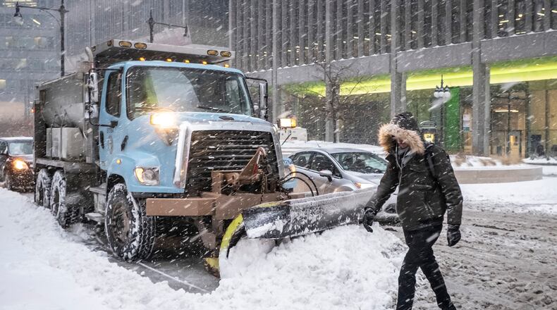 FILE - A man crosses Wacker Drive in front of a waiting city snowplow in Chicago, Jan. 28, 2019. (Rich Hein/Chicago Sun-Times via AP, File)