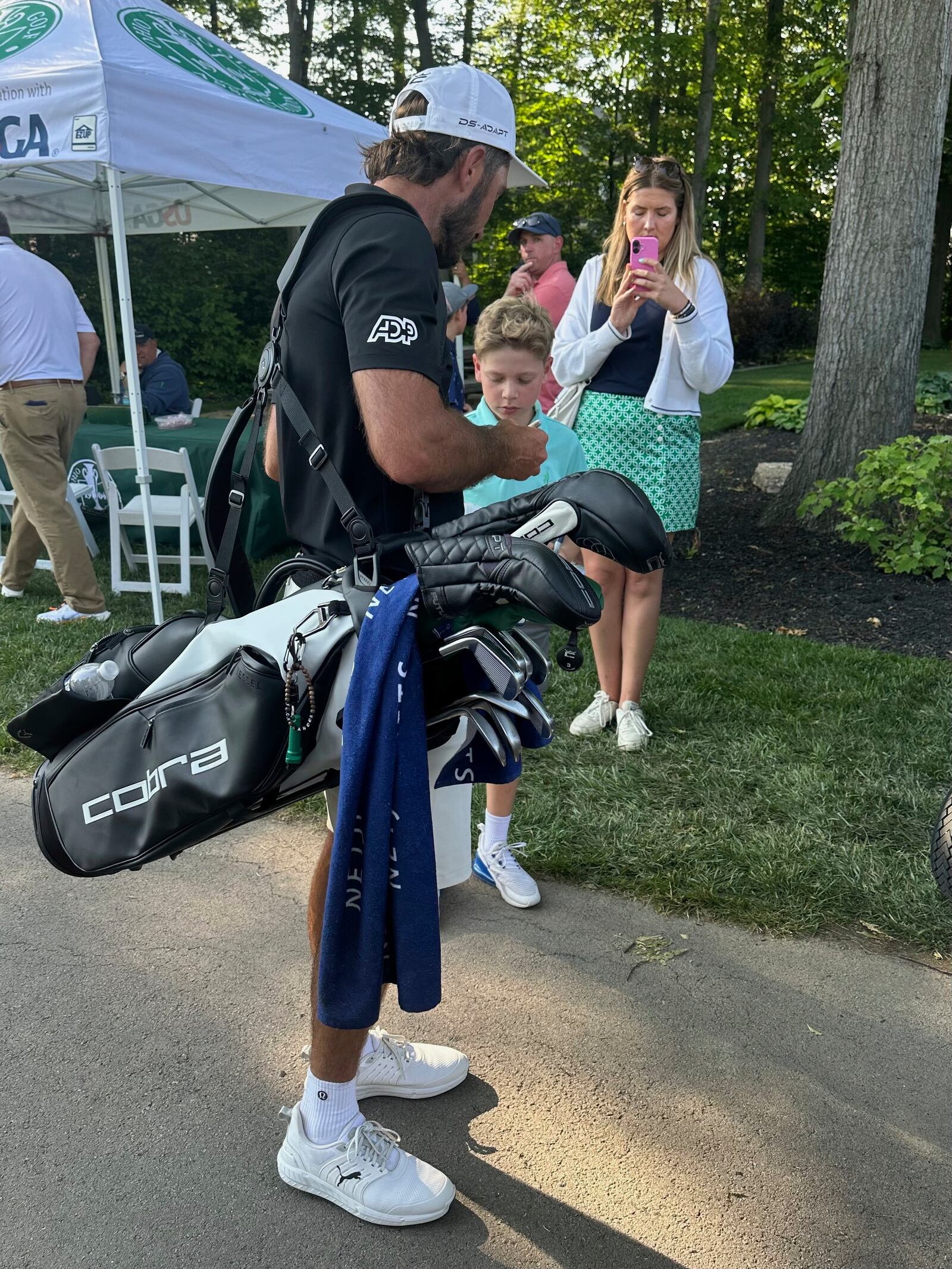 Max Homa stops to sign an autograph after his U.S. Open qualifier carrying his own bag after a split with his caddie, on Monday, June 2, 2025, in Columbus, Ohio. (AP Photo/Doug Ferguson)