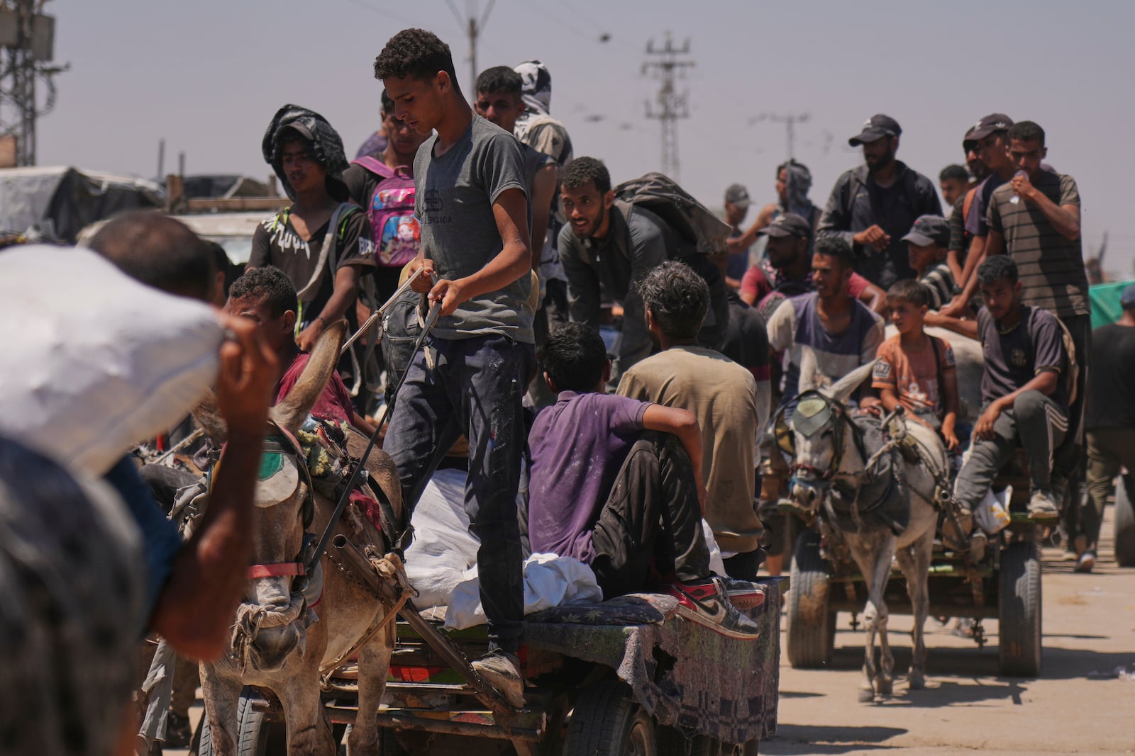 Palestinians carry bags containing food and humanitarian aid packages delivered by the Gaza Humanitarian Foundation, a U.S.-backed organization, in Rafah, southern Gaza Strip, Wednesday, June 25, 2025. (AP Photo/Abdel Kareem Hana)