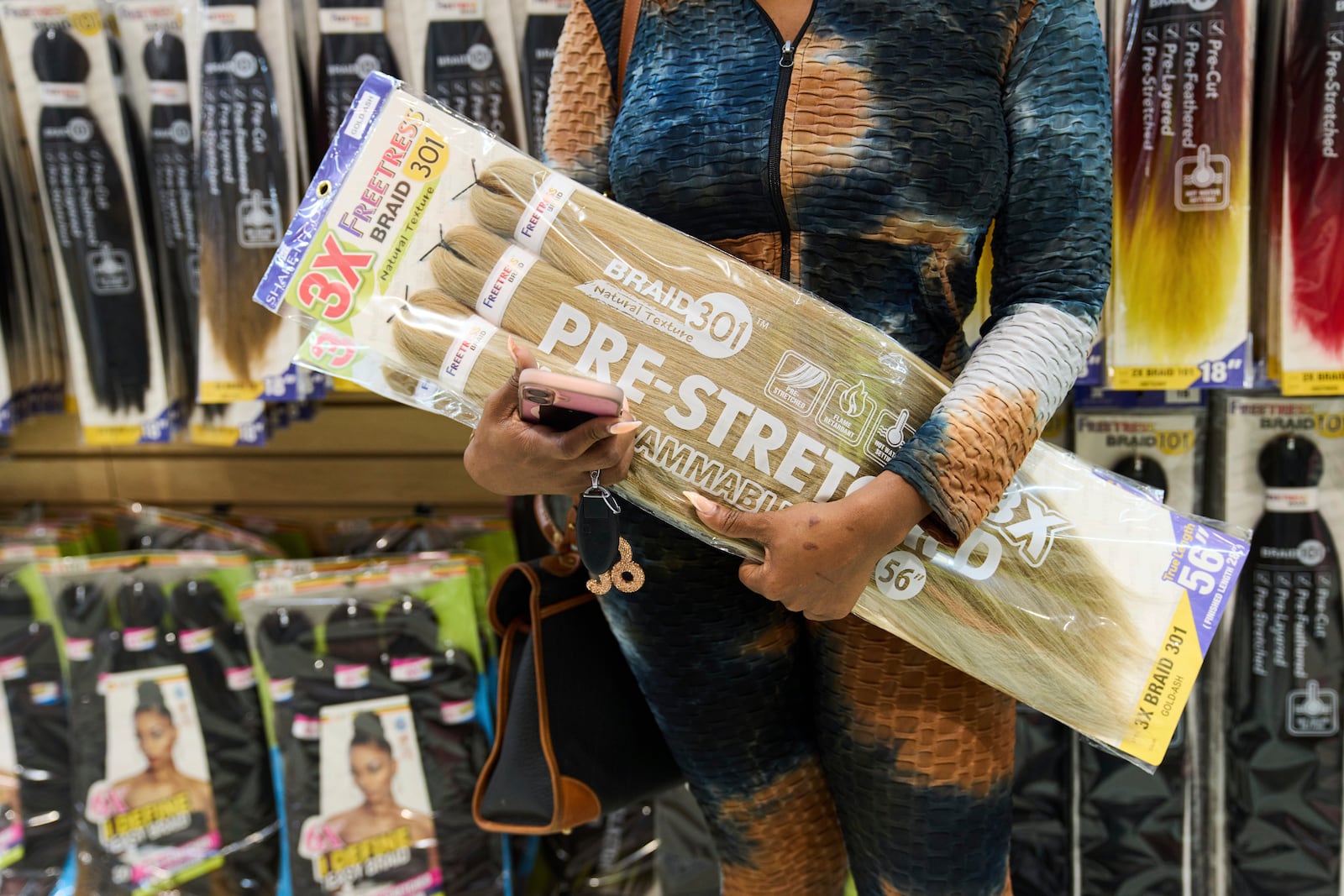 Hair stylist India Sands holds a pack of synthetic braiding hair that is made in China as she shops at Chapel Beauty, a beauty supply store in Decatur, Ga., Monday, May 5, 2025. (AP Photo/Stephanie Scarbrough)