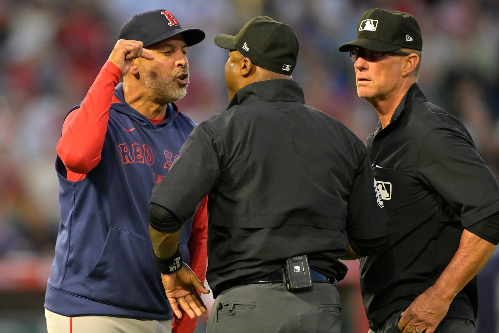 Boston Red Sox manager Alex Cora argues with umpire Alan Porter, center, as umpire Jim Wolf, right, looks on after he was ejected in the fifth inning during a baseball game against the Los Angeles Angels, Monday, June 23, 2025, in Anaheim, Calif. (AP Photo/Jayne Kamin-Oncea)