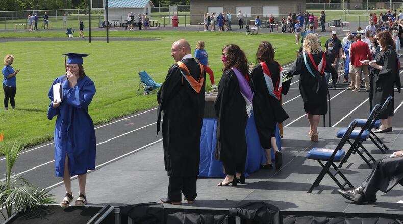Northwestern seniors and their families waited in alphabetical order around running track at Taylor Field as the school held its first social distanced graduation in May. BILL LACKEY/STAFF