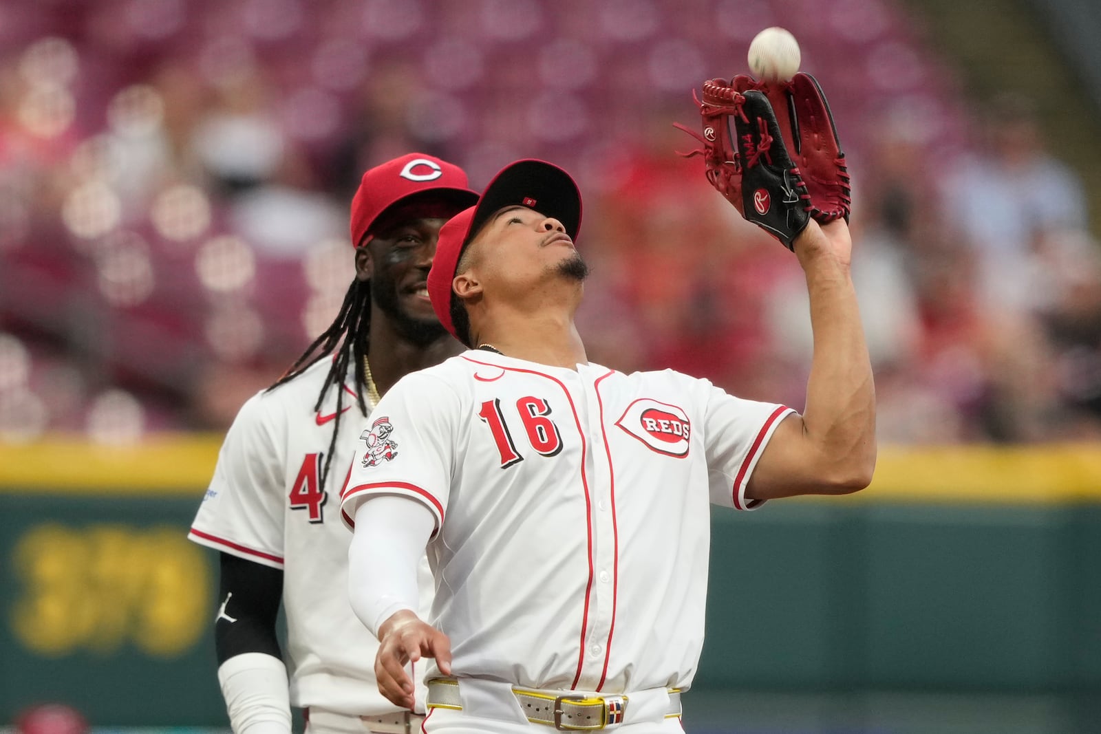 Cincinnati Reds third baseman Noelvi Marte (16) catches a pop fly hit by Miami Marlins' Agustín Ramírez during the first inning of a baseball game as shortstop Elly De La Cruz, left, looks on in Cincinnati, Monday, July 7, 2025. (AP Photo/Carolyn Kaster)