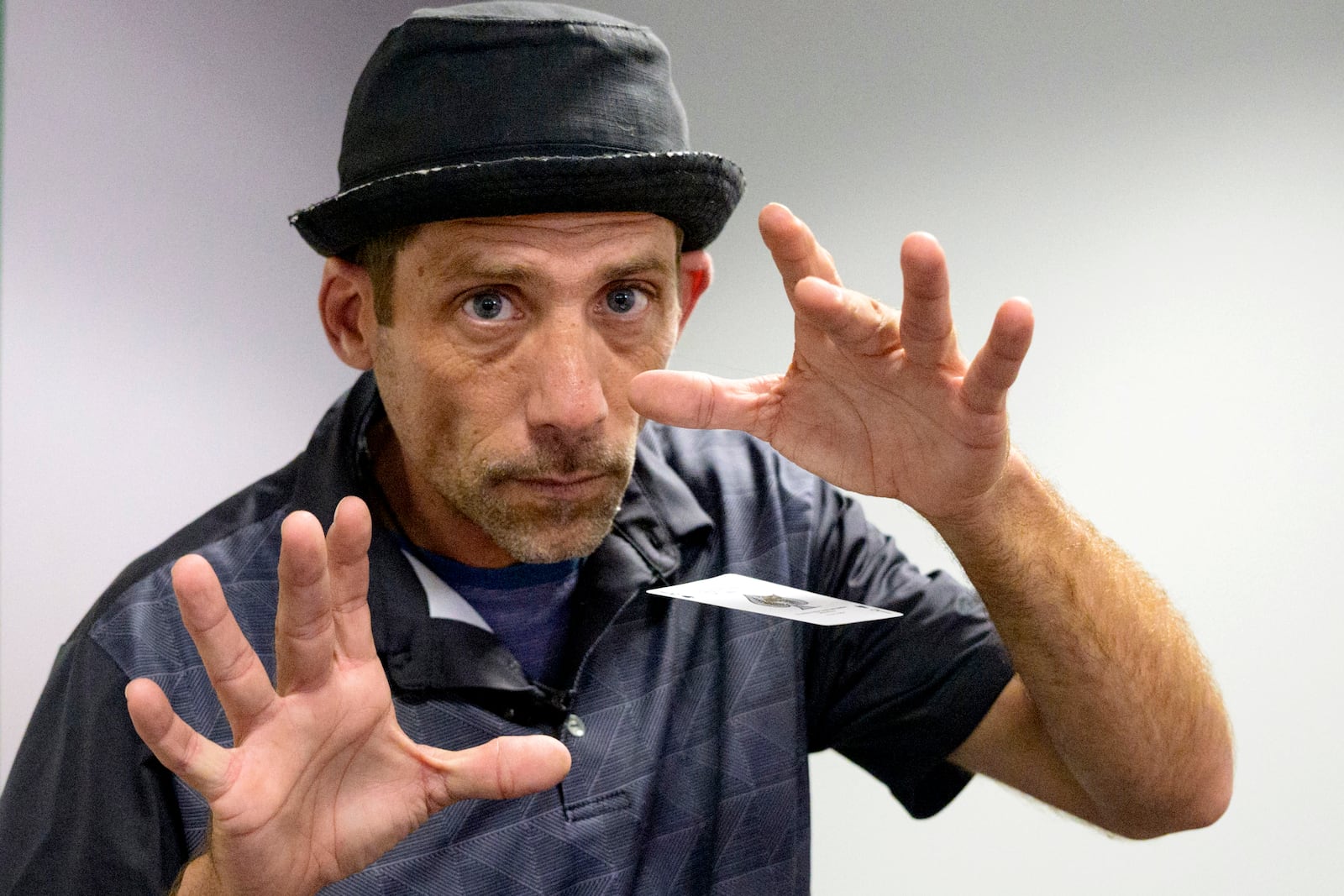 FILE - Paul Carpenter, a New Orleans magician, performs card tricks during an interview in New Orleans, Feb. 23, 2024. (AP Photo/Matthew Hinton, File)