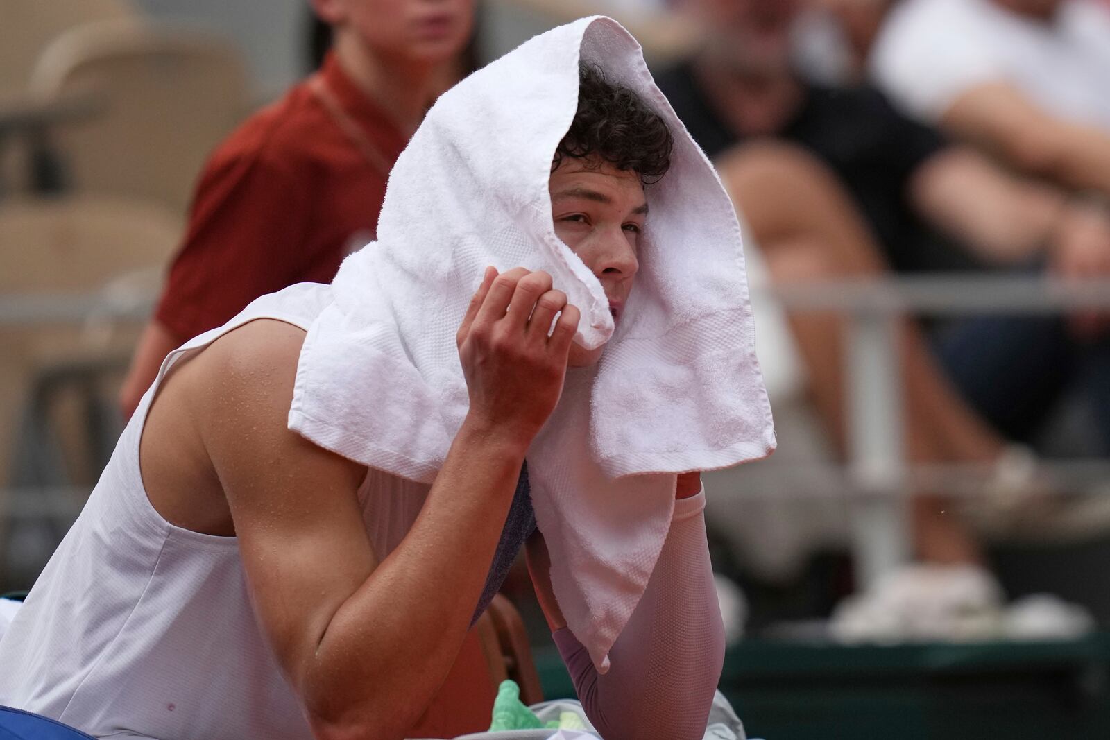 Ben Shelton of the U.S. sits during a break as he plays Spain's Carlos Alcaraz during their fourth round match of the French Tennis Open, at the Roland-Garros stadium, in Paris, Sunday, June 1 2025. (AP Photo/Christophe Ena)