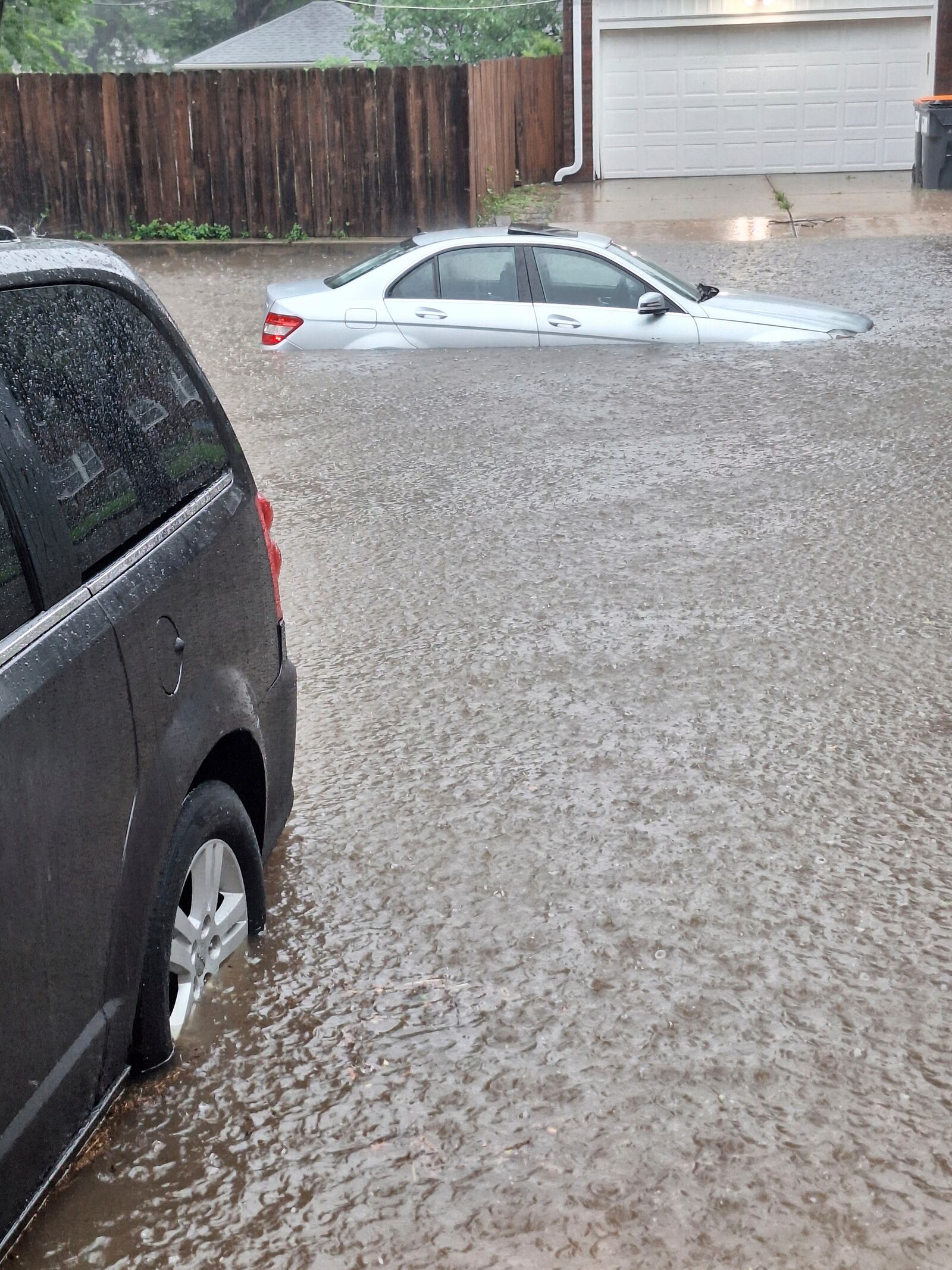 This photo provided by Colin Fee, a vehicle is surrounded by flood waters as heavy rains caused flash flooding in the Wichita area of south-central Kansas on Tuesday, June 3, 2025. (Colin Fee via AP)