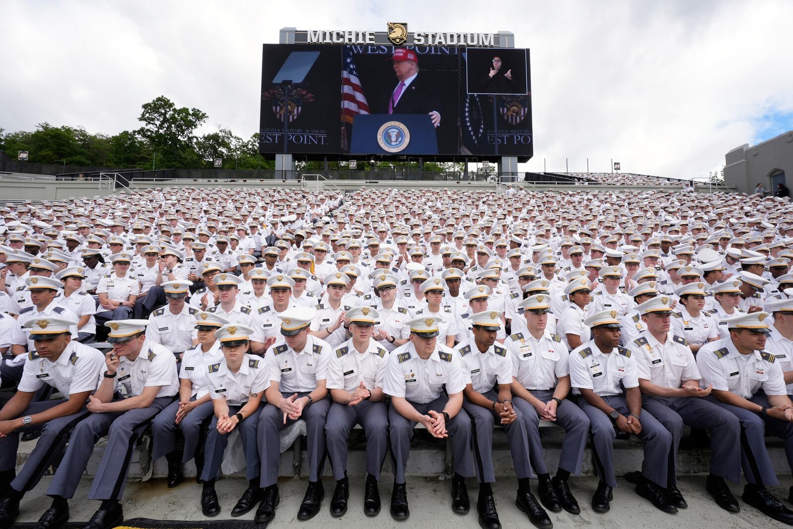 Cadets listen as President Donald Trump, seen on screen, speaks to United States Military Academy graduating cadets during commencement ceremonies in West Point, N.Y., Saturday, May 24, 2025. (AP Photo/Manuel Balce Ceneta)
