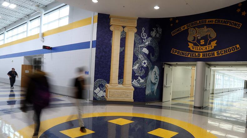Students walk through the atrium of Springfield High School. Springfield city schools are at risk of not graduating about 40 percent of its students if Ohio does not change its graduation requirement. BILL LACKEY/STAFF