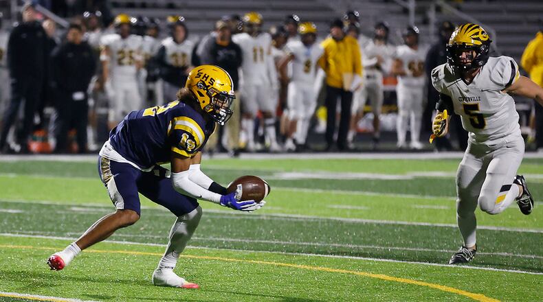 Da'Shawn Martin catches a pass as Centerville's Matthew Karpinsky moves in during Friday's playoff game. BILL LACKEY/STAFF