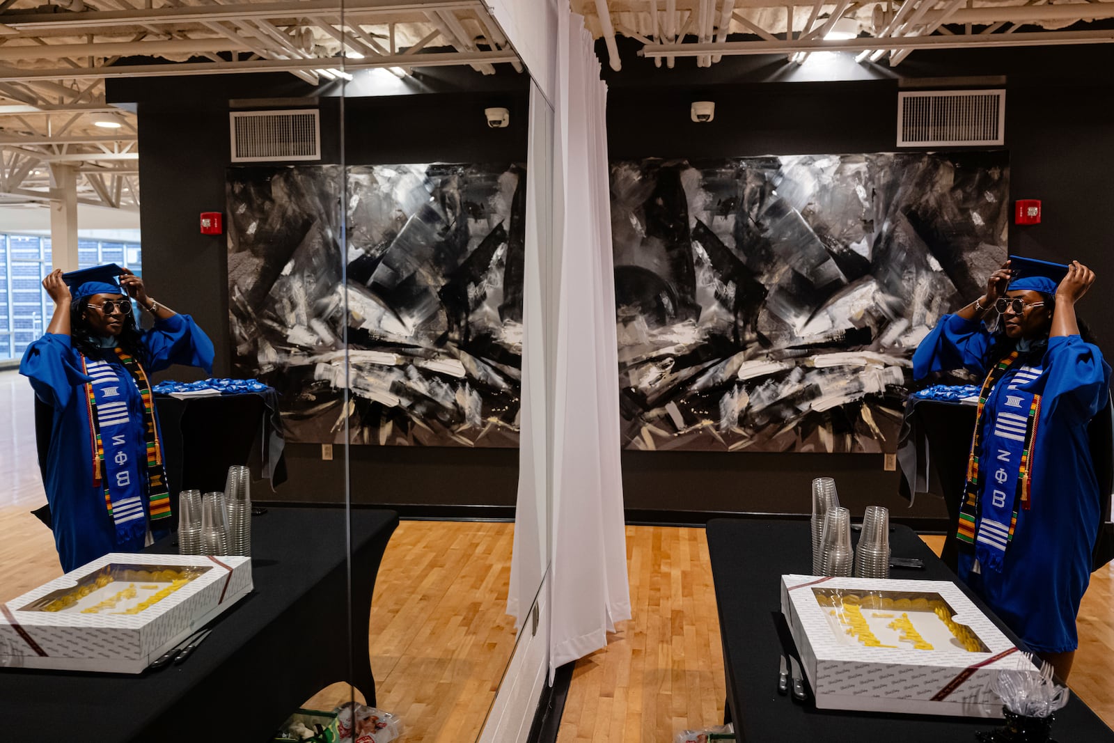 Jocelyn Grimsley straightens her cap in a mirror ahead of the Senior Salute at Lyric Theatre in Lexington, Ky., Wednesday, May 7, 2025. (AP Photo/Jon Cherry)