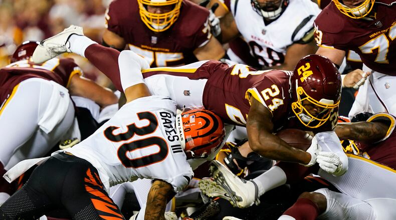 Washington Football Team running back Antonio Gibson (24) lunges for yardage as he is tackled by Cincinnati Bengals free safety Jessie Bates (30) during the first half of a preseason NFL football game Friday, Aug. 20, 2021, in Landover, Md. (AP Photo/Susan Walsh)