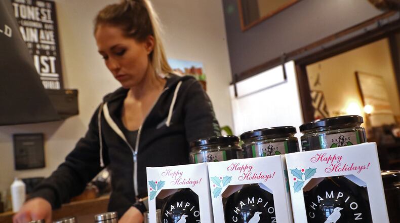 Kelcie Webster, manager of Champion City Guide & Supply, straightens up a holiday display Wednesday. BILL LACKEY/STAFF