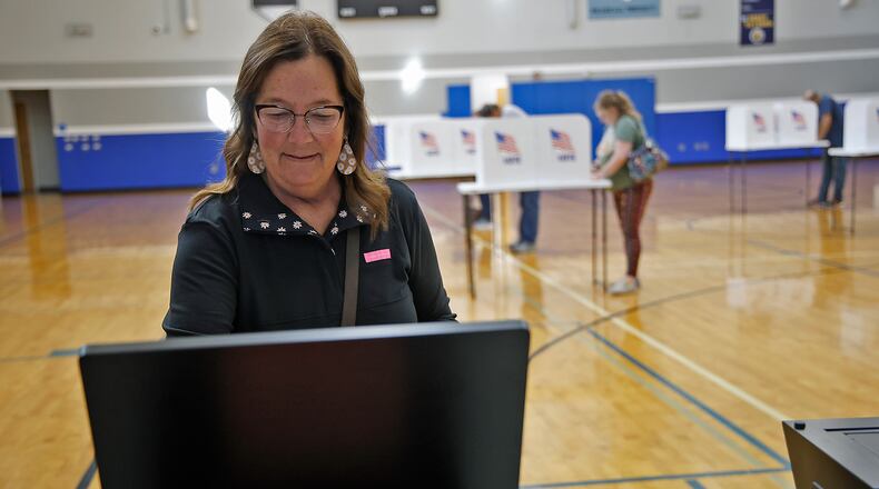 Vikki Hayden slides her ballot in the voting machine Tuesday, Nov. 7, 2023 at Roosevelt Middle School. BILL LACKEY/STAFF