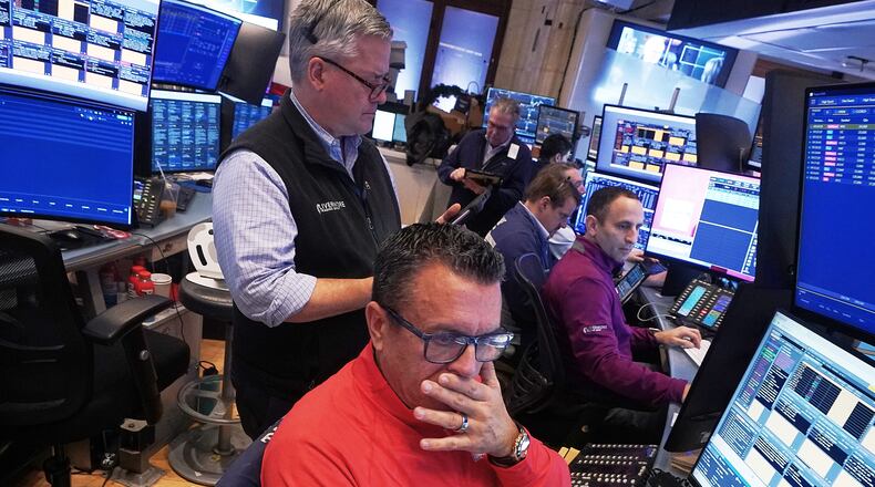 Trader Robert Finnerty Jr., foreground, works with colleagues on the floor of the New York Stock Exchange, Monday, Jan. 12, 2026. (AP Photo/Richard Drew)